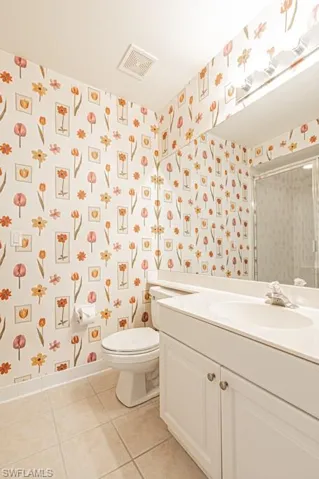 Recently painted white - Half-Bathroom featuring vanity, toilet, and tile patterned floors