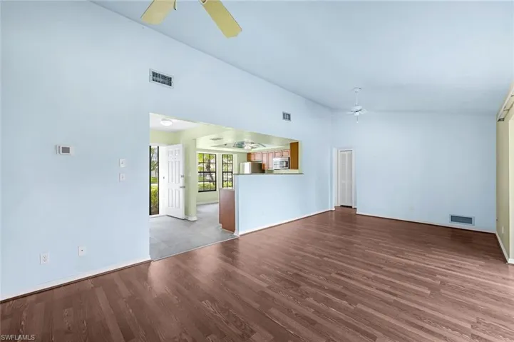 Unfurnished living room featuring high vaulted ceiling, ceiling fan, and hardwood / wood-style floors