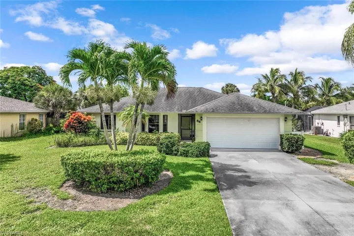 Ranch-style home with a garage and a front lawn
