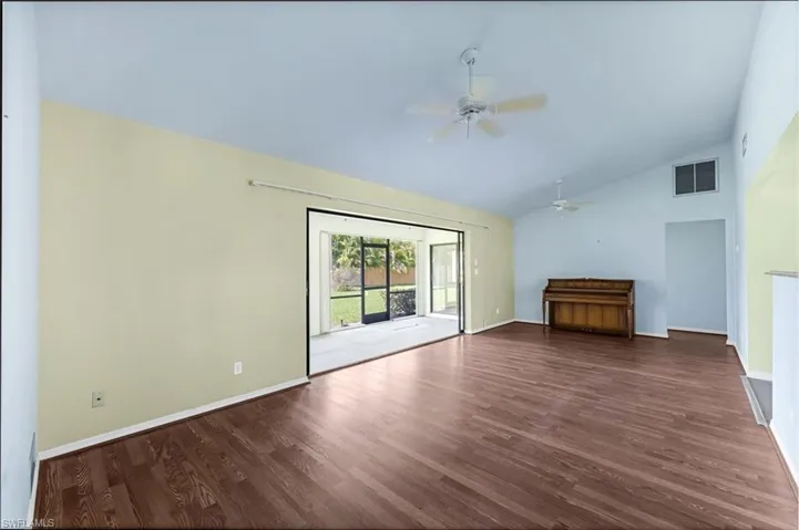 Unfurnished living room featuring hardwood / wood-style floors, high vaulted ceiling, and ceiling fan