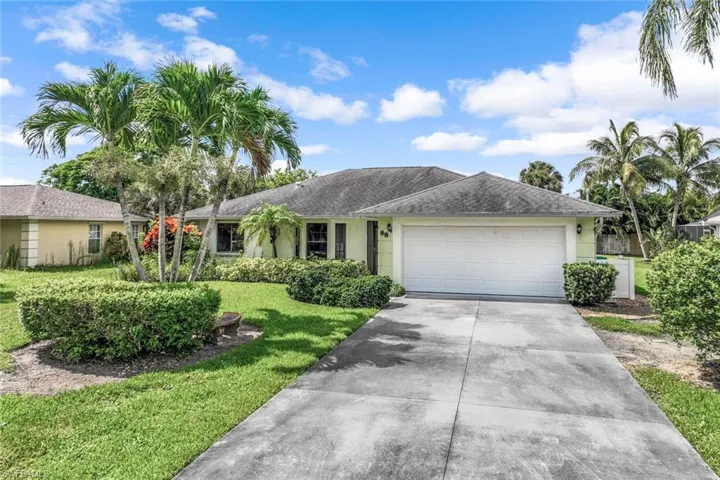 Ranch-style home with a garage and a front lawn