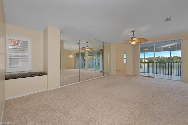 Unfurnished room with a water view, ceiling fan, a wealth of natural light, and carpet floors