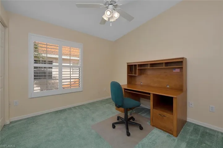 Unfurnished office with carpet, vaulted ceiling, and ceiling fan