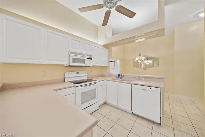 Kitchen featuring white cabinets, breakfast bar, and corian counters