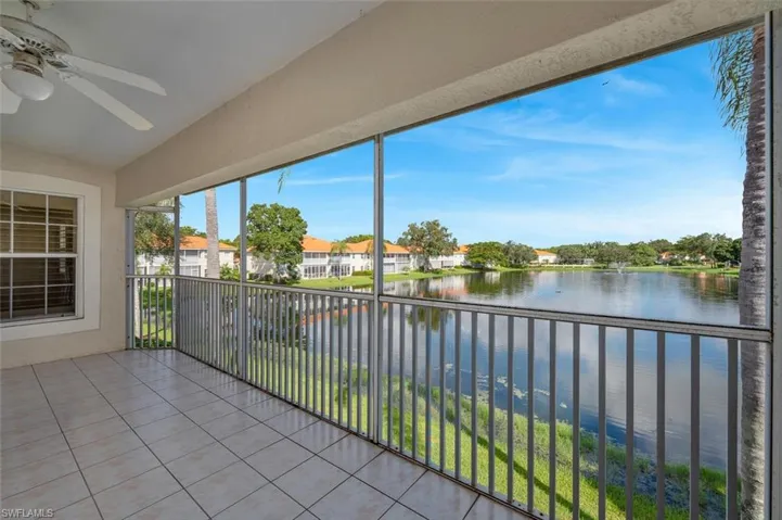 Unfurnished sunroom with lofted ceiling, a water view, and ceiling fan