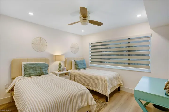 Guest bedroom with 2 twin beds and custom window treatment.