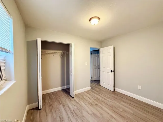 Unfurnished bedroom featuring light wood-type flooring and a closet