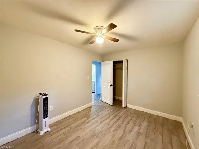 Unfurnished bedroom featuring light wood-type flooring, a ceiling fan, and a closet