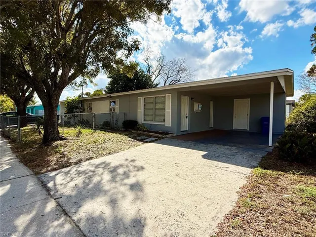 View of front facade featuring driveway and a carport