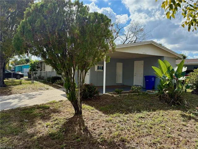 View of front facade with concrete driveway and a carport