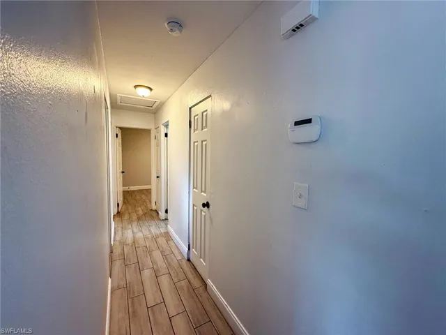 Hallway with wood finish floors and attic access