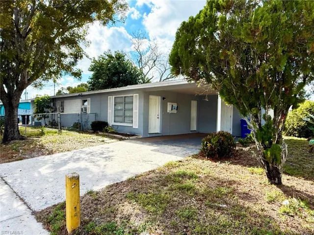 Ranch-style house featuring concrete driveway, concrete block siding, and an attached carport