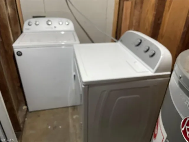 Laundry area featuring washer and dryer and wood walls