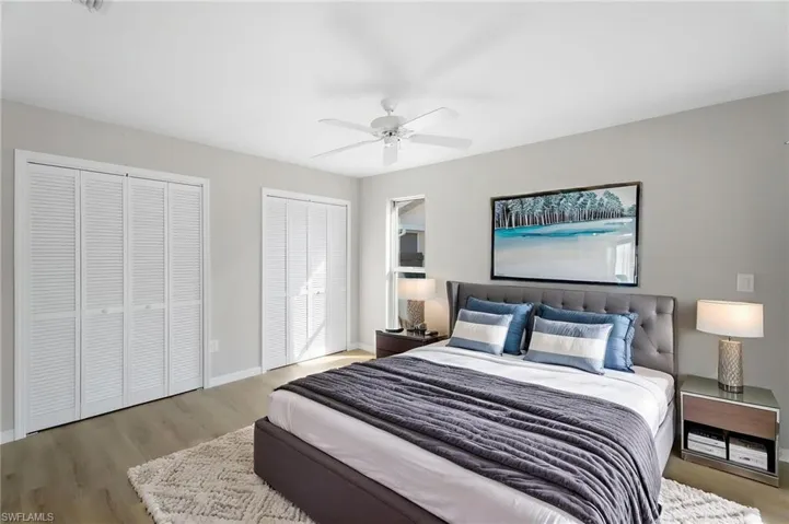 Computer virtual primary Bedroom with multiple closets, a ceiling fan, wood finished floors, and baseboards