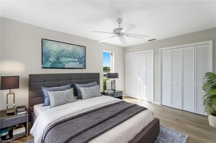 Computer generated virtual guest Bedroom with two closets, ceiling fan, and light wood-style floors