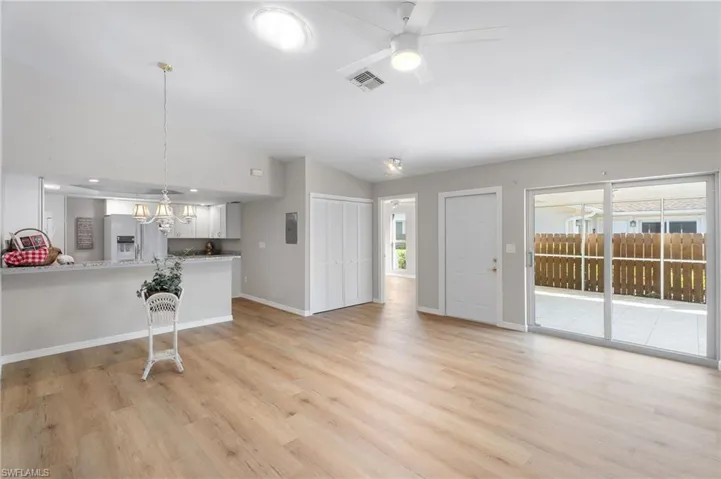 Living area featuring a wealth of natural light, baseboards, light wood-style flooring and entrance to lanai.