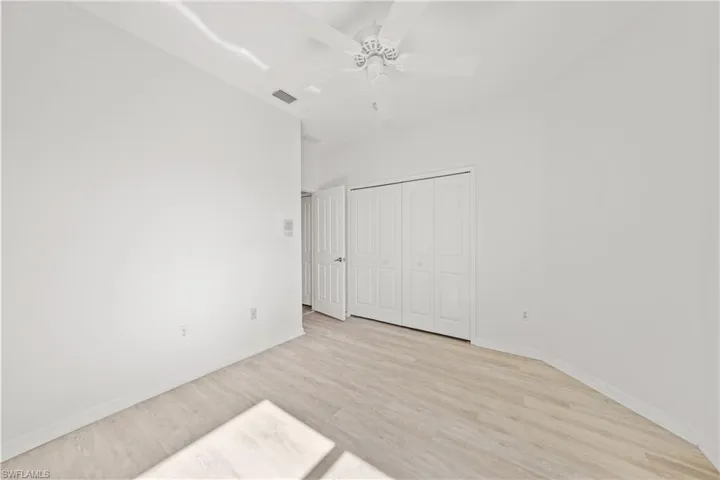Unfurnished bedroom with light wood-type flooring, a closet, and ceiling fan
