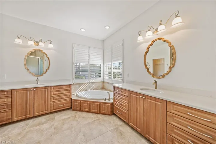 Bathroom featuring tile patterned floors, a washtub, and vanity