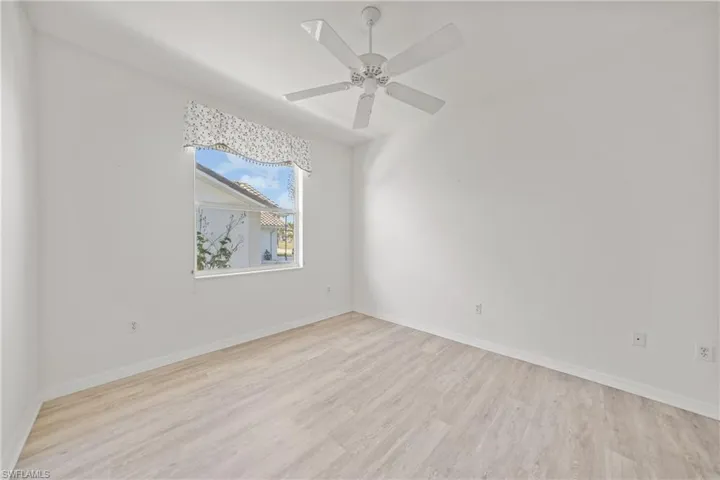 Unfurnished room with ceiling fan and light wood-type flooring