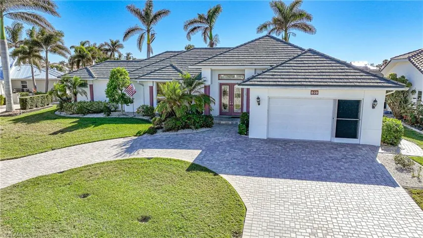 View of front of home with a garage, a front yard, and french doors