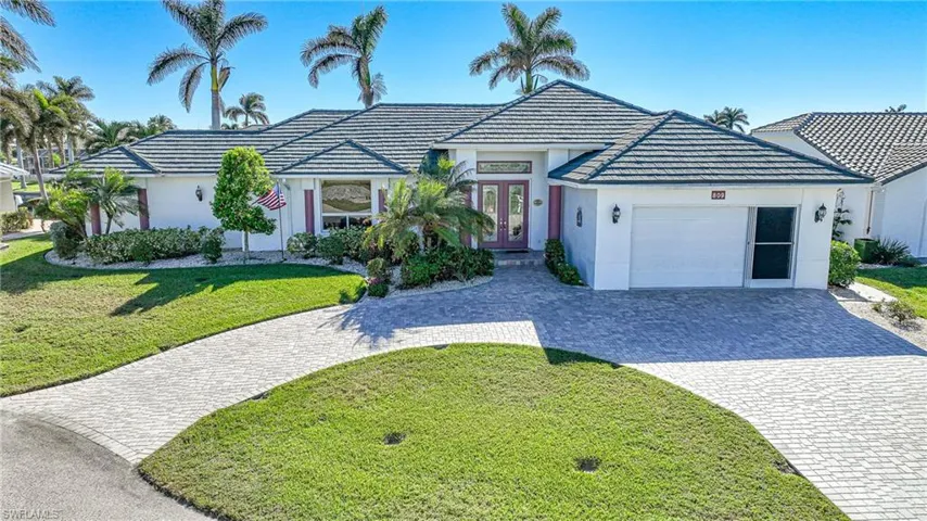Ranch-style home featuring a front yard, french doors, and a garage
