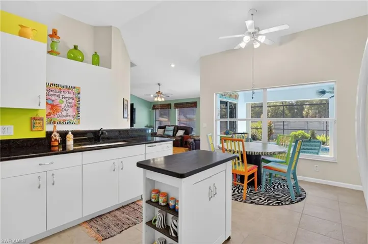 Kitchen with white cabinetry, ceiling fan, open floor plan, light tile patterned floors, and open shelves