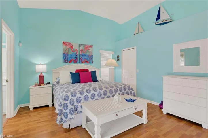 Bedroom with light wood-type flooring and vaulted ceiling