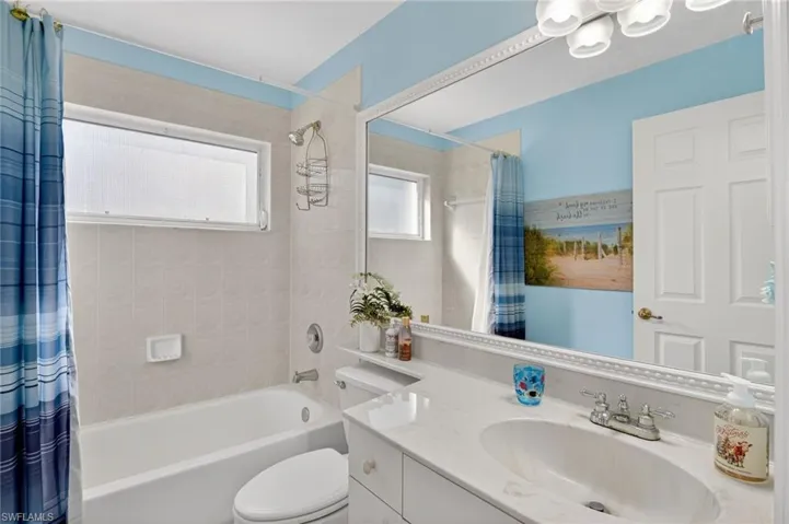 Full bathroom with shower / bath combo with shower curtain and vanity