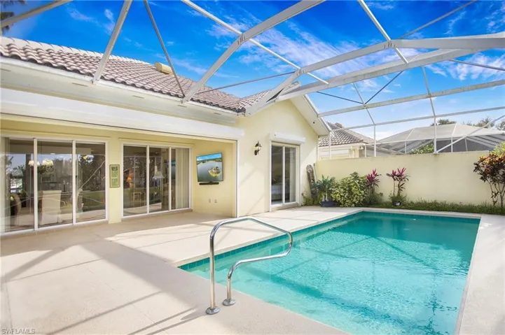 View of swimming pool featuring a lanai and a patio area