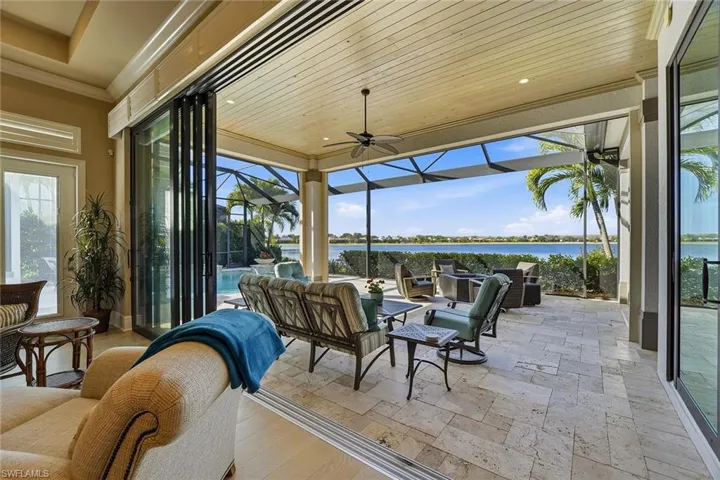 View of patio featuring a lanai, a sunroom, outdoor lounge area, a water view, and ceiling fan