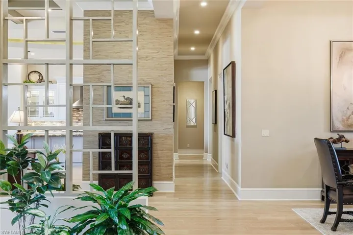 Hall featuring wood finished floors, ornamental molding, and recessed lighting