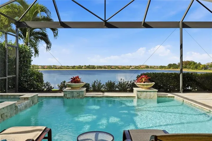 Outdoor pool with glass enclosure, a sunroom, and a water view