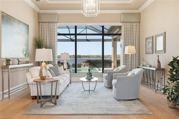 Living area with a water view, wood finished floors, crown molding, and a sunroom