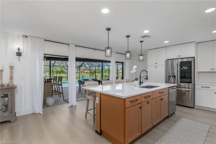 Kitchen with light countertops, stainless steel appliances, decorative backsplash, a sink, and visible vents