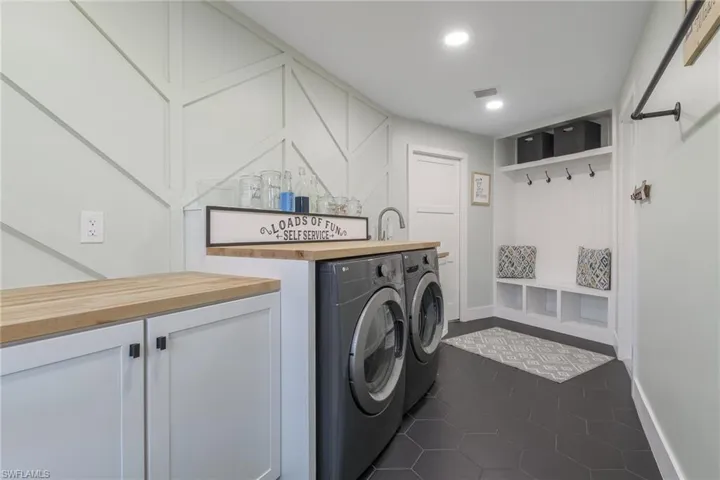 Laundry room with visible vents, recessed lighting, a dry bar, dark tile patterned flooring, and separate washer and dryer