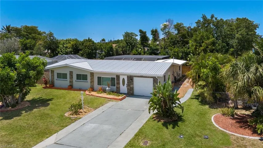 Plenty of parking in both the front and side driveways.  Metal roof and Impact window throughout the home.  New metal roof installed in 2022.  Decorative front stone veneer.  The western rear exposure provides incredible sunsets.