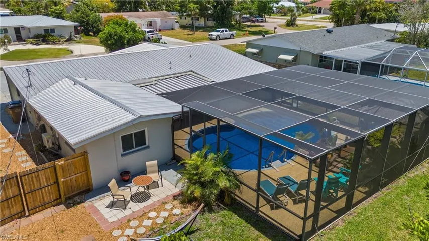 Oversized screened-in lanai provides lots of space for entertaining, lounge chairs, and fun by the pool and tiki bar.  You can also enjoy peace of mind with the new metal roof installed in 2022.