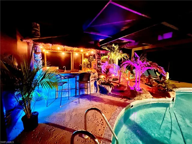 Color changing outdoor lighting and cafe lights make the outdoor tiki bar area tons of fun for an evening get-together with friends!