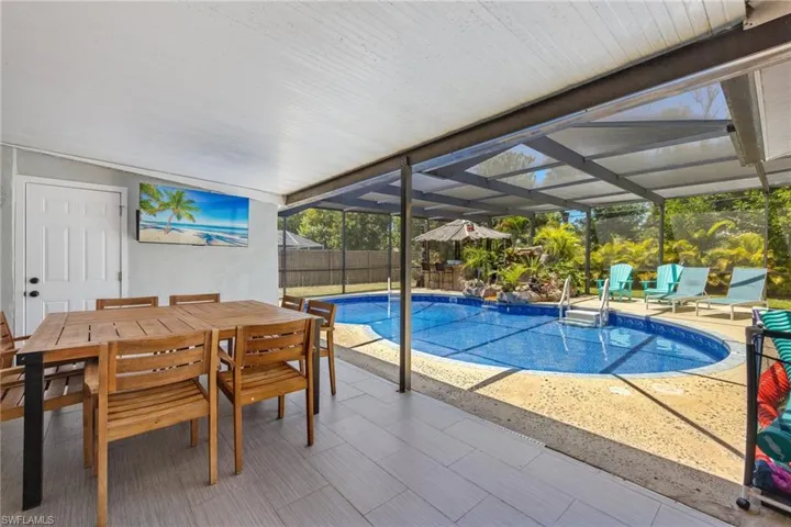 Great under roof outdoor dining space with TV and teak wood table for 8 people.