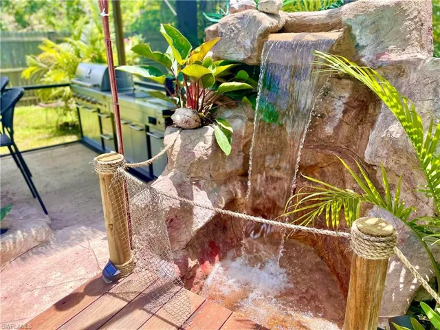 Custom built waterfall with steam into the pool.  A walkway with bridge crossed the stream into the outdoor kitchen.