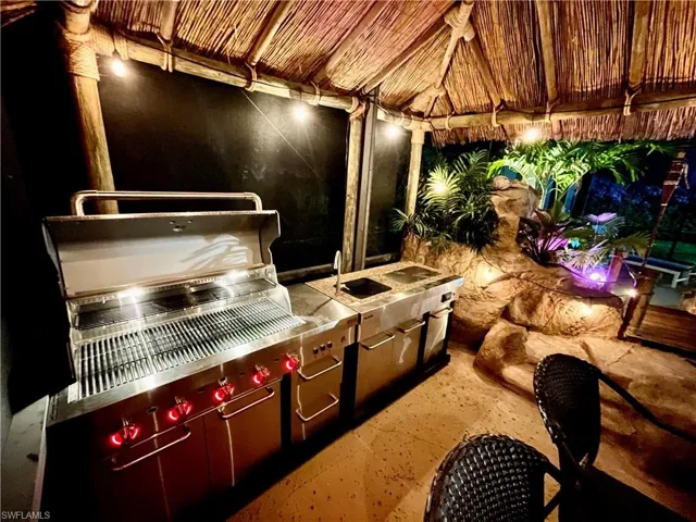 Outdoor kitchen with 5 burner grill, sink, built in cooler, and granite/stainless steel counter.  Picture from 2 years ago when the grill was brand new.