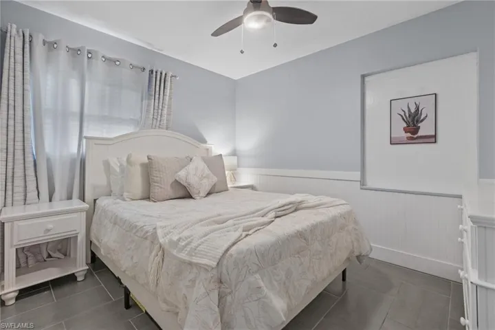 Guest bedroom 2 with queen bedroom set and impact windows.