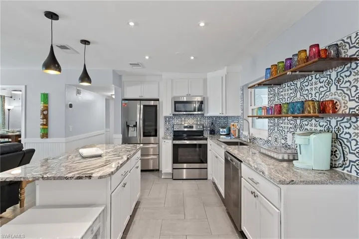 The modern island pendants and recessed lighting help make cooking an enjoyable experience in this bright and open kitchen.  The colorful dishware has been well thought out to provide an artistic pop of color that your guests are sure to enjoy!