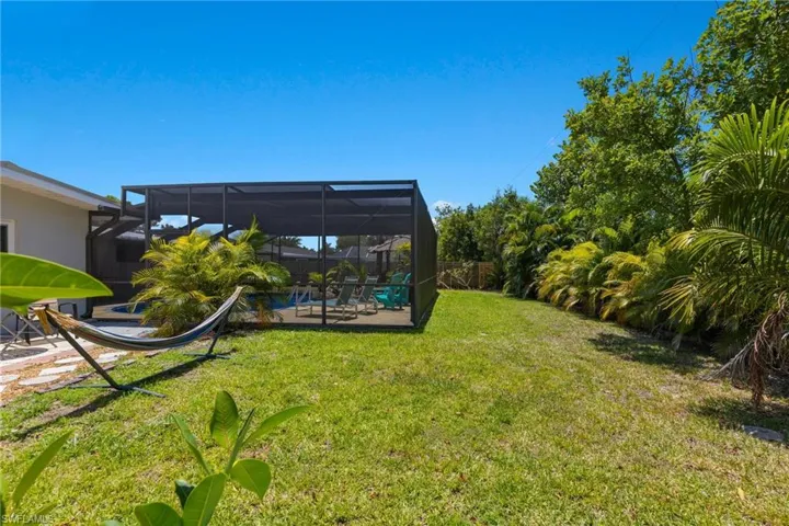 The fenced in backyard is great for horseshoe, cornhole, or throwing a baseball with the kids.  Tropical palms line the back of the yard.