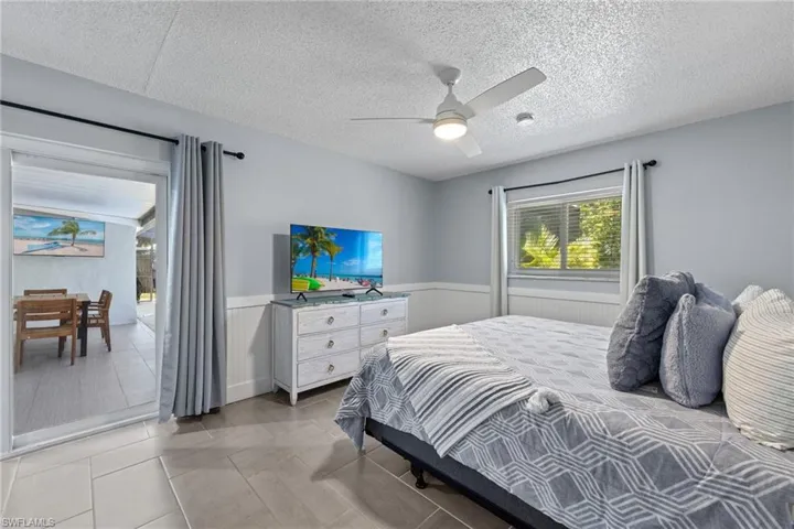 Primary bedroom with private bathroom and impact sliding glass doors out to the pool area. This room has a separate mini split cooling system adding comfort and control over your specific sleeping temperature.  Enjoy peace of mind with impact windows throughout the home.