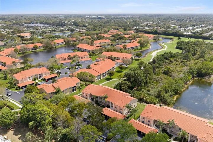 Aerial view of property and surrounding area featuring a nearby body of water and nearby suburban area