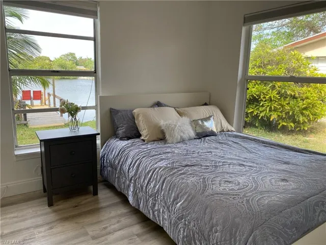 Bedroom featuring wood finished floors and a water view