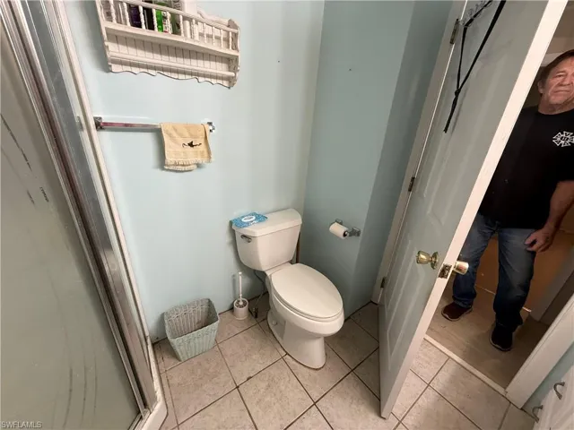 Full bathroom featuring toilet and light tile patterned floors