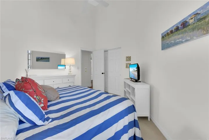 Bedroom with a towering ceiling, carpet flooring, a ceiling fan, and a closet