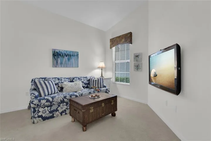 Living area featuring carpet floors and high vaulted ceiling